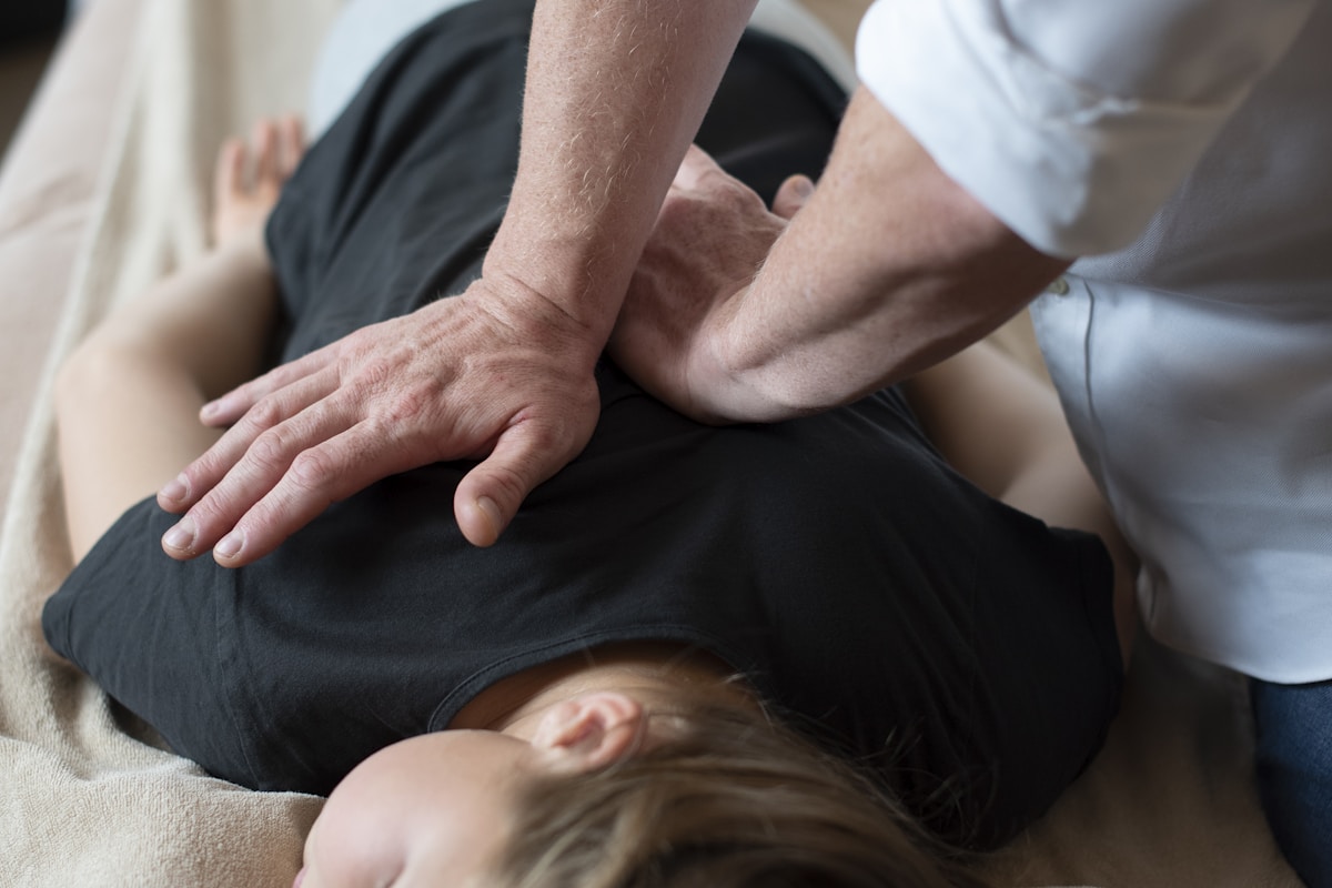 Chiropractor performing gentle spinal adjustment on a patient